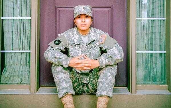 穿着美国军装的女人坐在门前